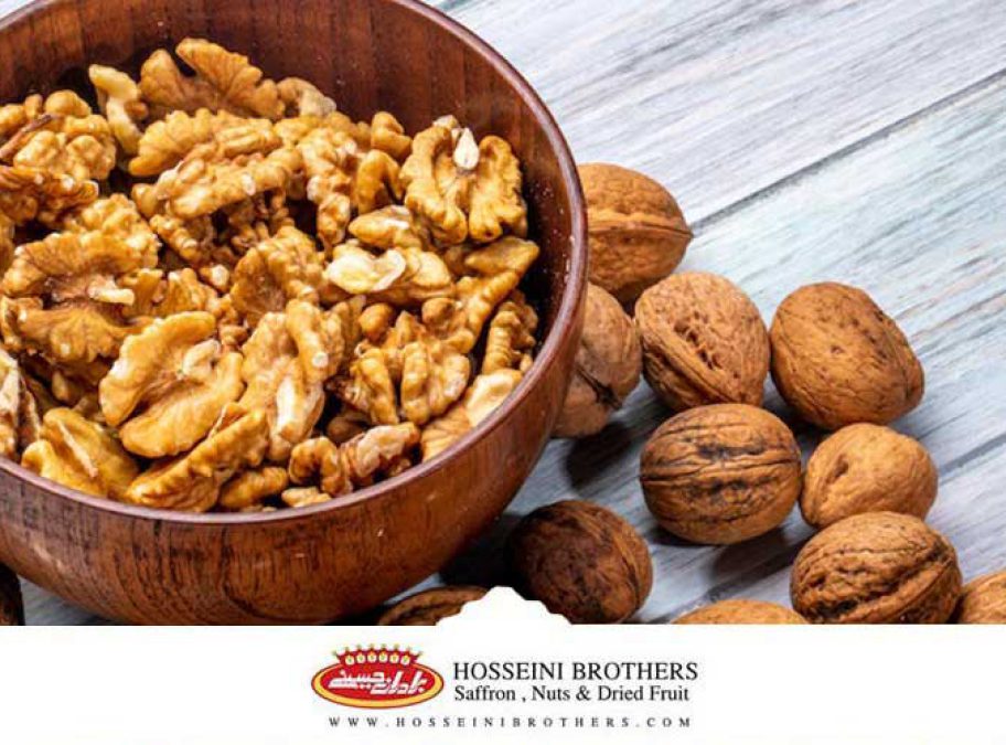 یک ظرف چوبی حاوی گردو و چند گردو در کنار آن